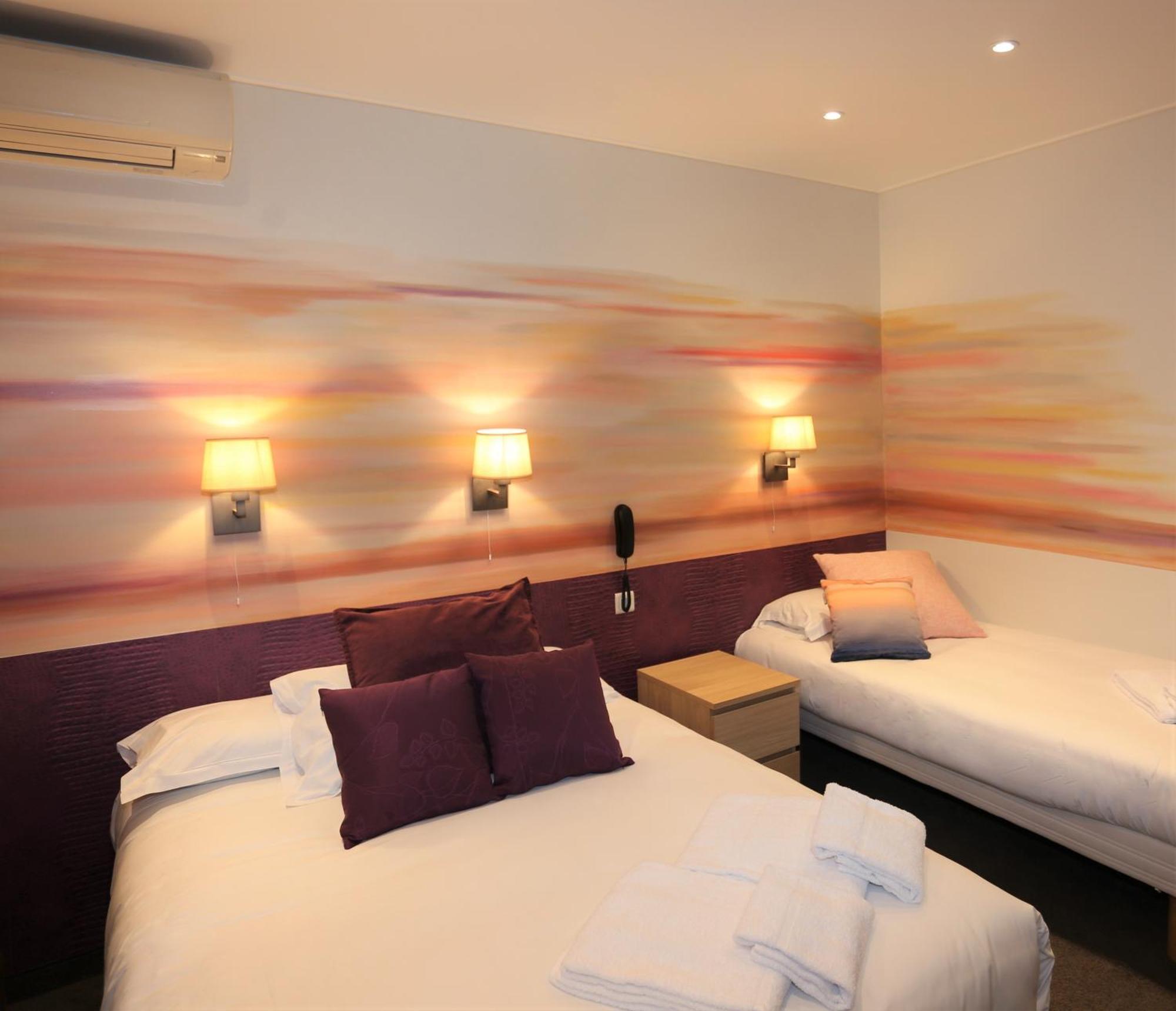 Triple Room with window overlooking a painted wall